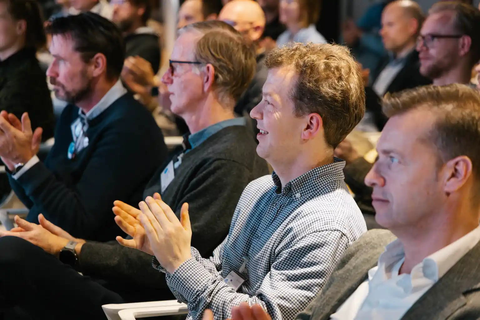 Attendees applauding during a conference session