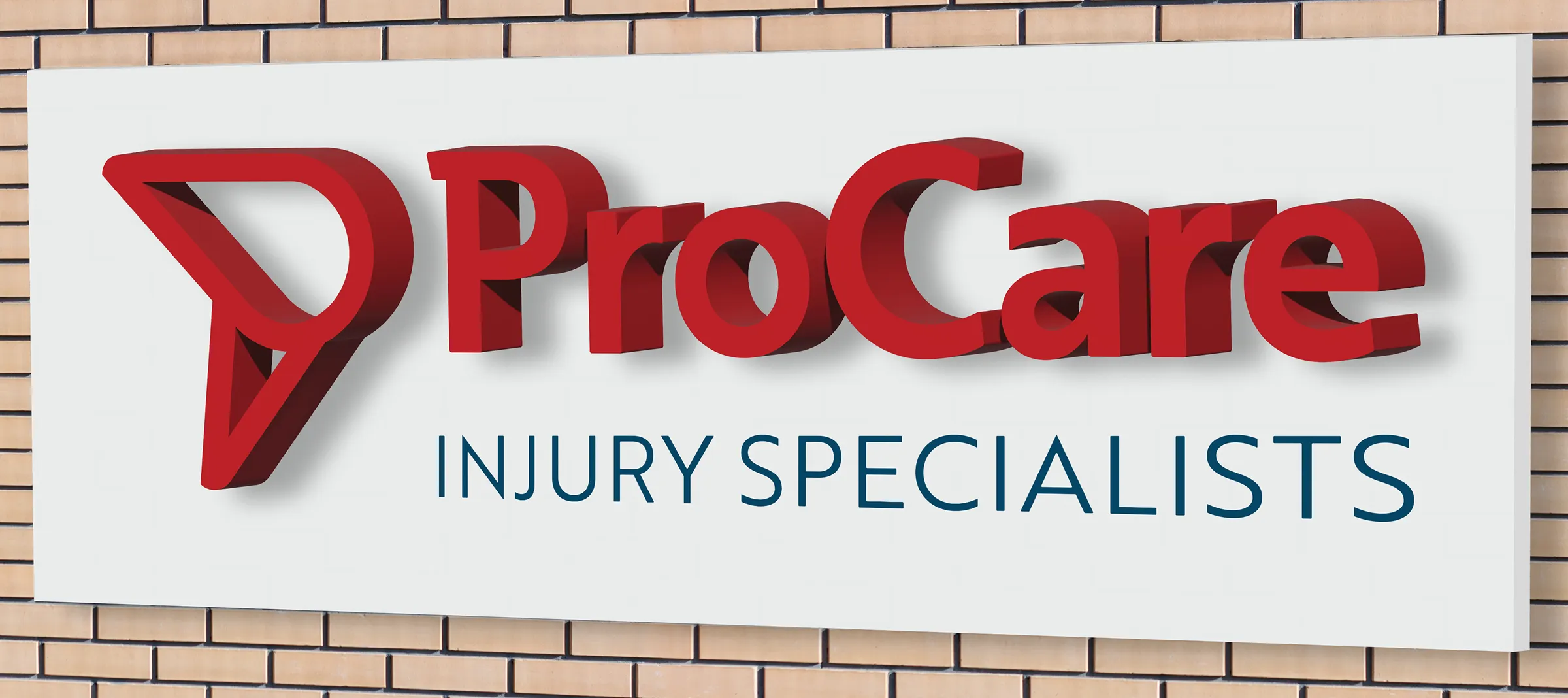 Sign on brick wall displaying 'ProCare' in large red letters with 'Injury Specialists' underneath in smaller blue letters.