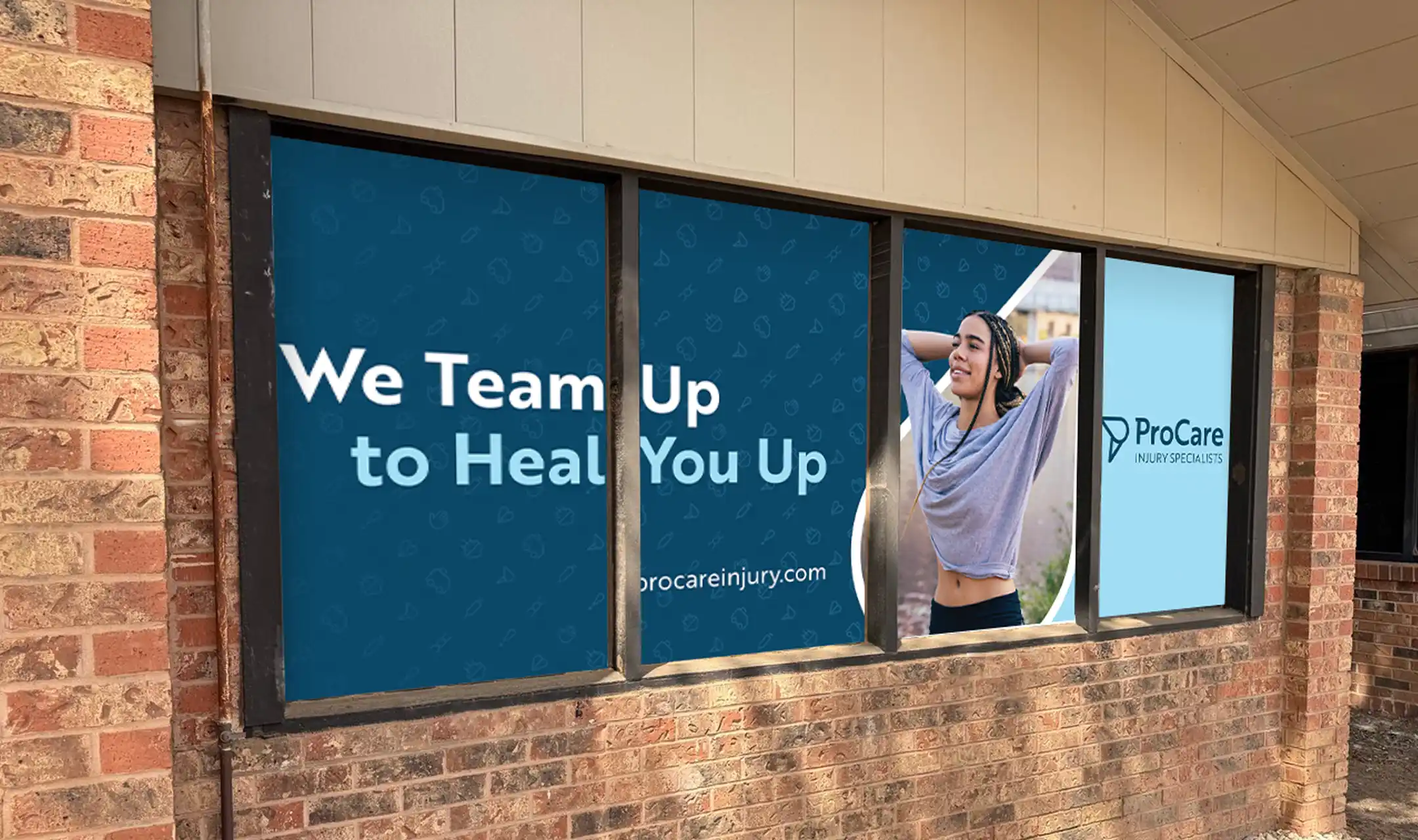 Window signage on a brick building with text 'We Team Up to Heal You Up', a woman stretching, and ProCare Injury Specialists logo.
