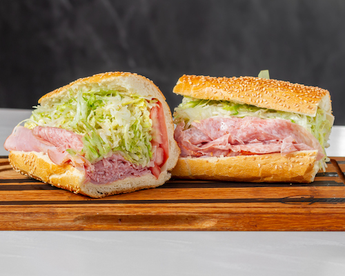 A sandwich cut in half on a wood serving board