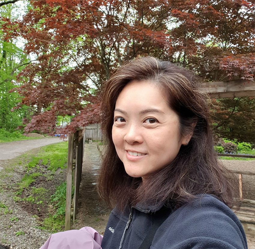 A photo of me, Luann, smiling in front of a tree.