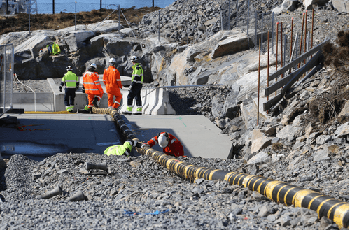 Team of engineers working on a power cable on land