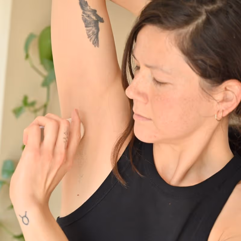 Applying All Tree Roots natural deodorant. 