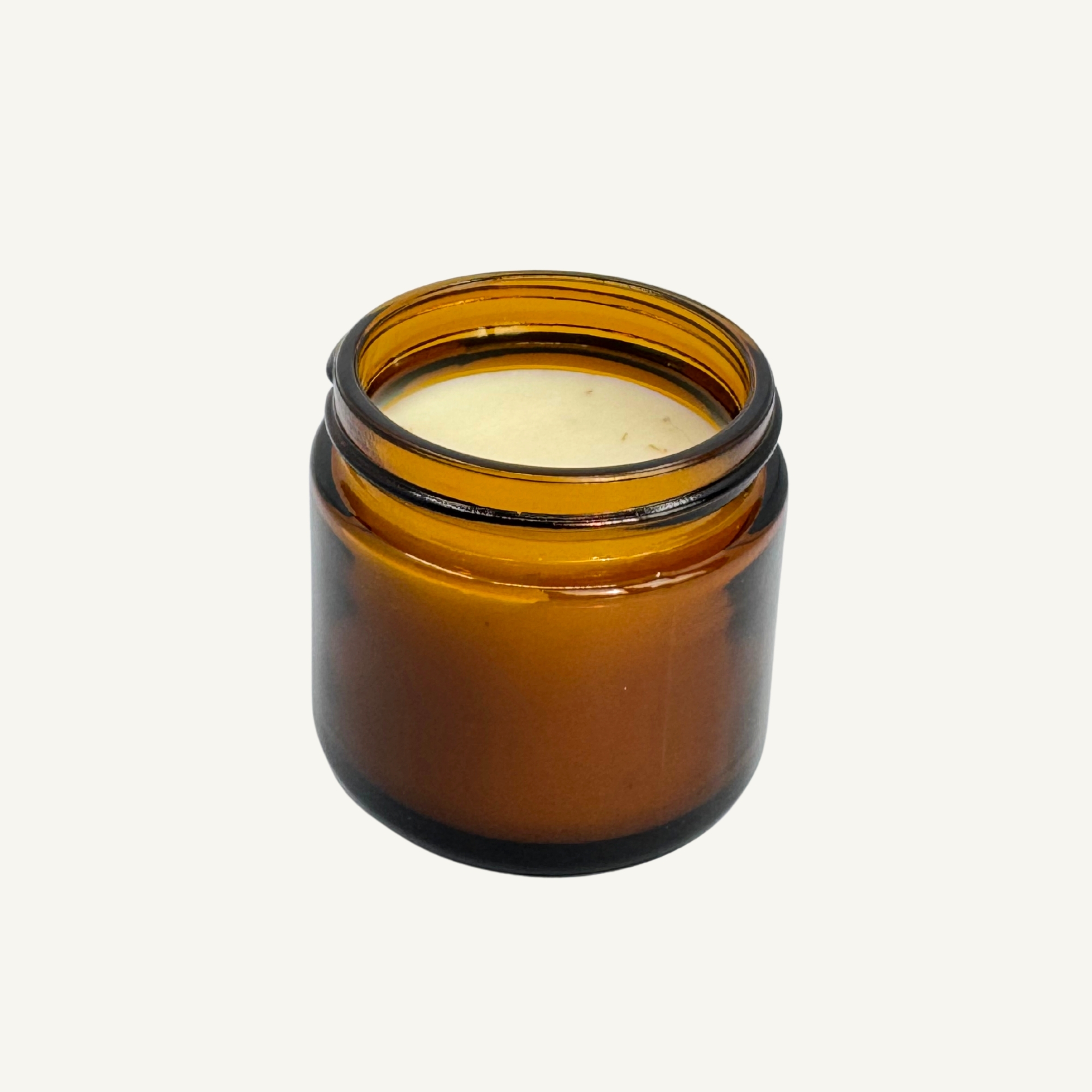 Open 2 oz amber glass jar of All Tree Roots Healer Salve showing the off-white herbal balm on a soft neutral background.