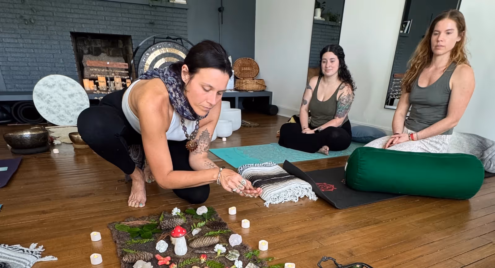 Participant contributing to a nature-inspired altar during a reflective group sound healing and wellness gathering.