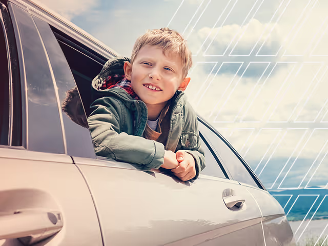 A young boy stares out of a used car window.