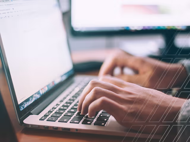 Hands typing on a laptop keyboard