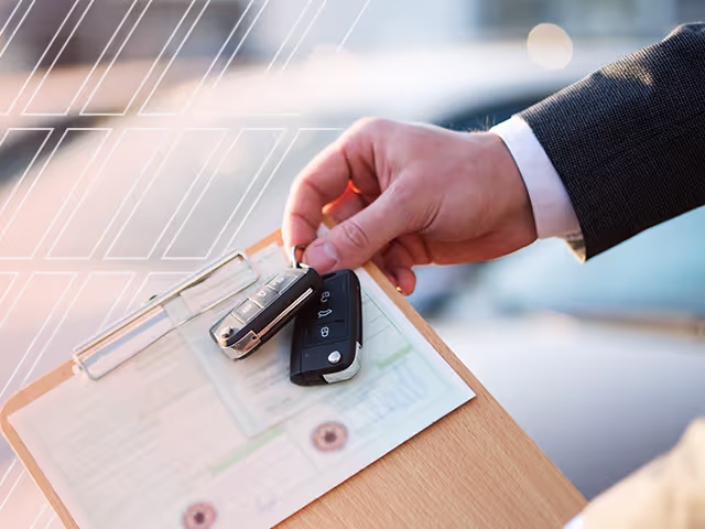 A man holding keys to a used car and the car title