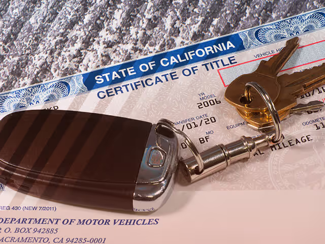 A car title with a set of car keys laying on top of it