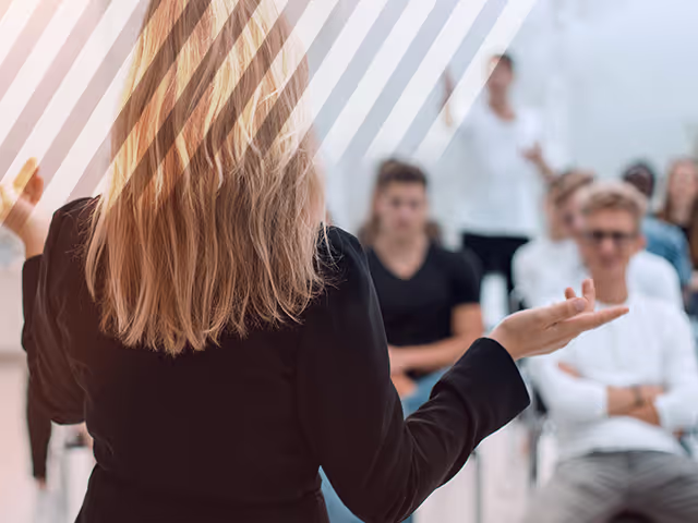 A Sales Trainer teaches the class on tactics she uses to sell used cars. 