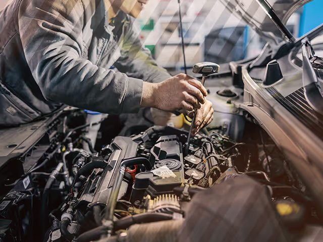 An Automotive Technician works on a car engine