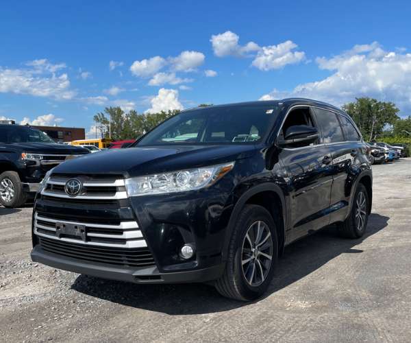 A black 2018 Toyota Highlander parked in dealer lot