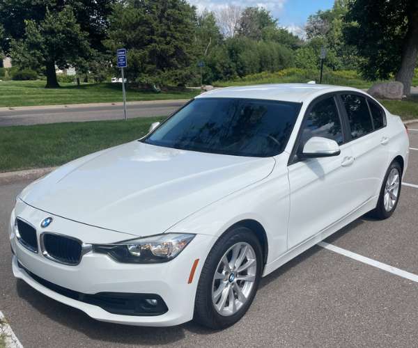 A used white 2016 BMW 3 series in a parking lot