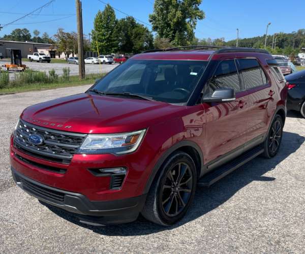 A used red 2019 Ford Explorer in a crowded parking lot