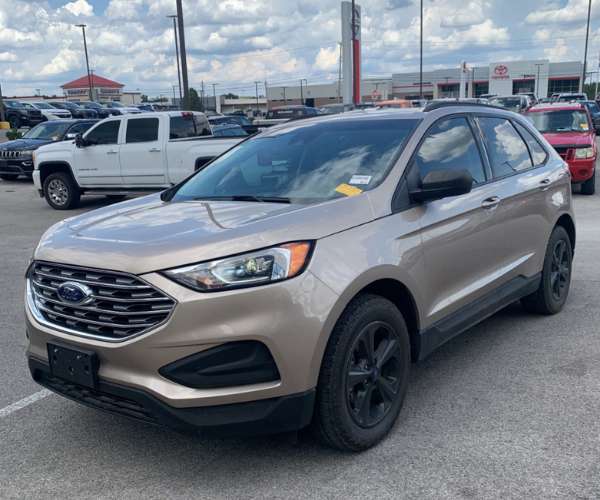 A brown 2020 Ford Edge in a dealer parking lot