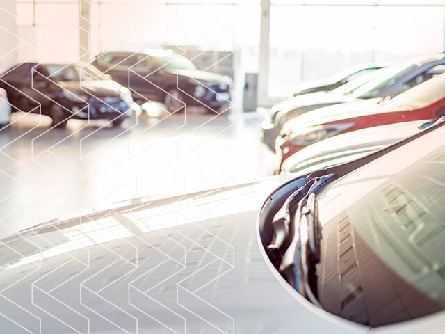 A close up of a car hood in a car dealer lobby. 