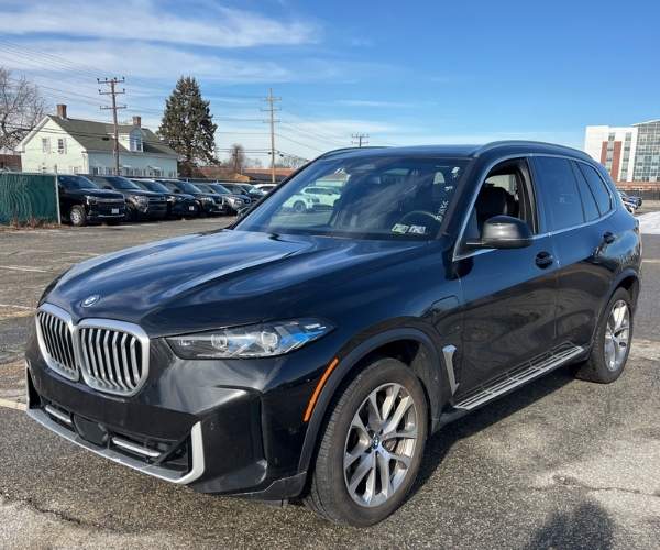 A used black 2025 BMW X5 in a parking lot