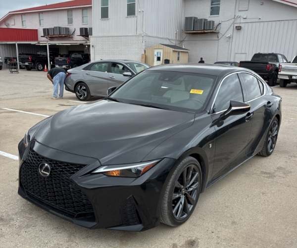 A black Lexus in dealer parking lot