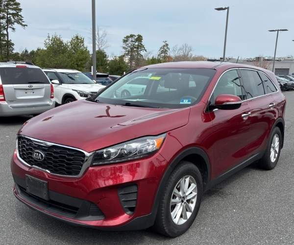 A red 2020 Kia Sorento in a dealer lot.