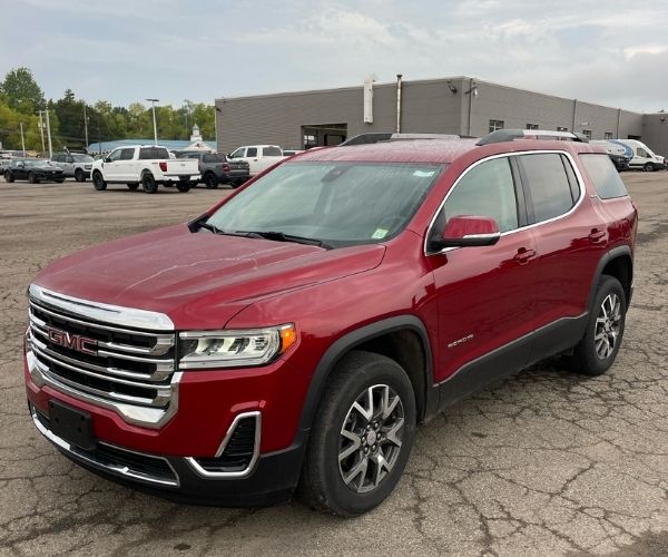 A red 2022 GMC Acadia in a dealership parking lot