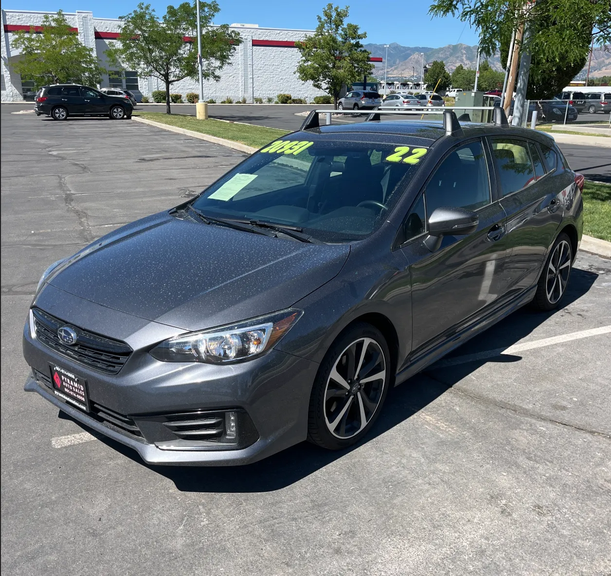 A blue Honda Civic in a busy dealer parking lot