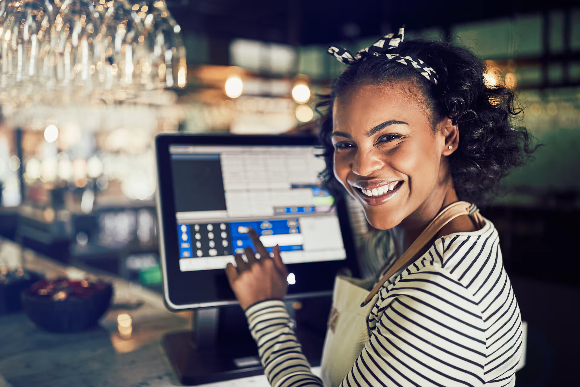 Smiling waitress using a restaurant point of sale terminal