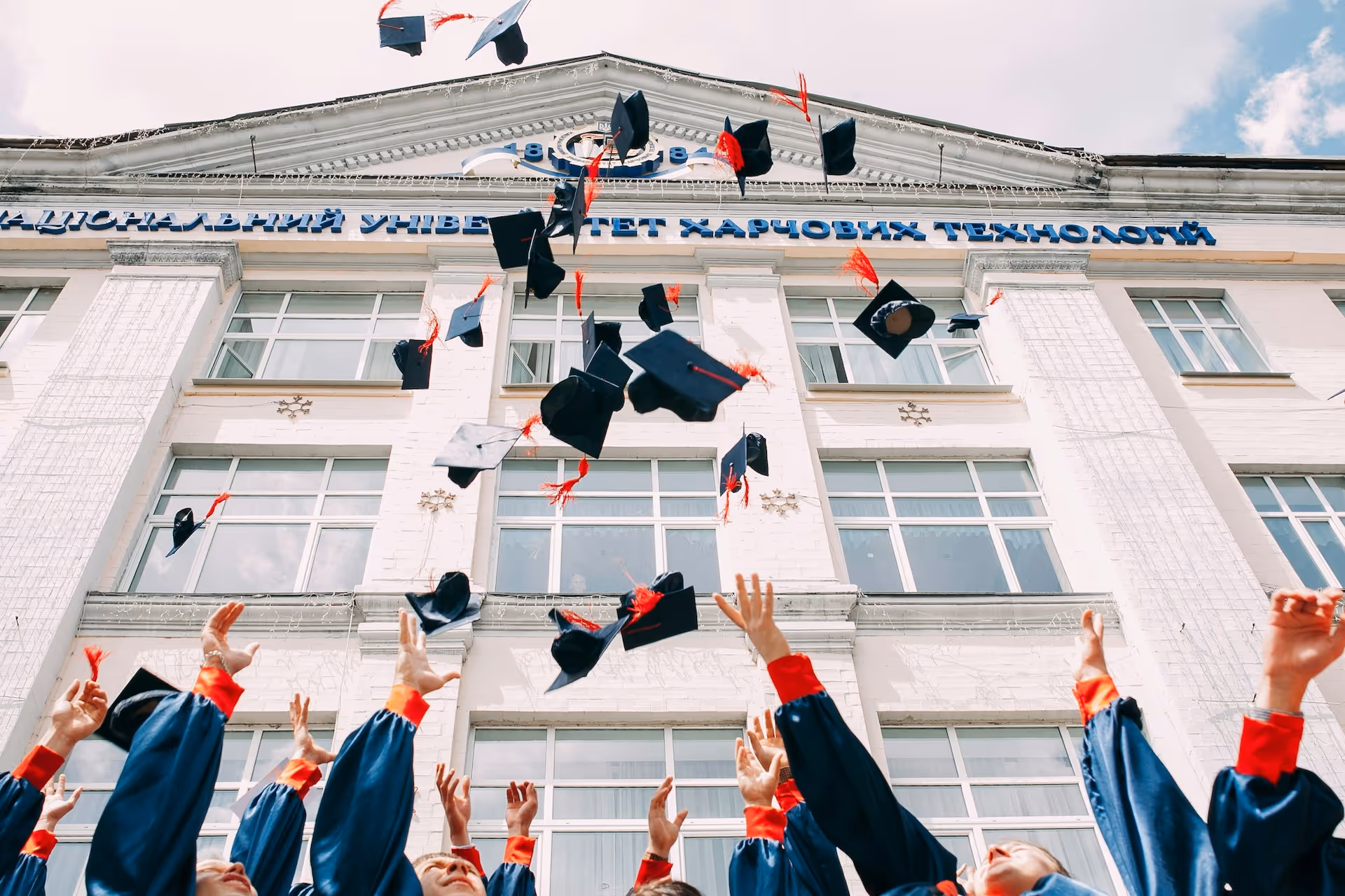 Graduates throw their caps up