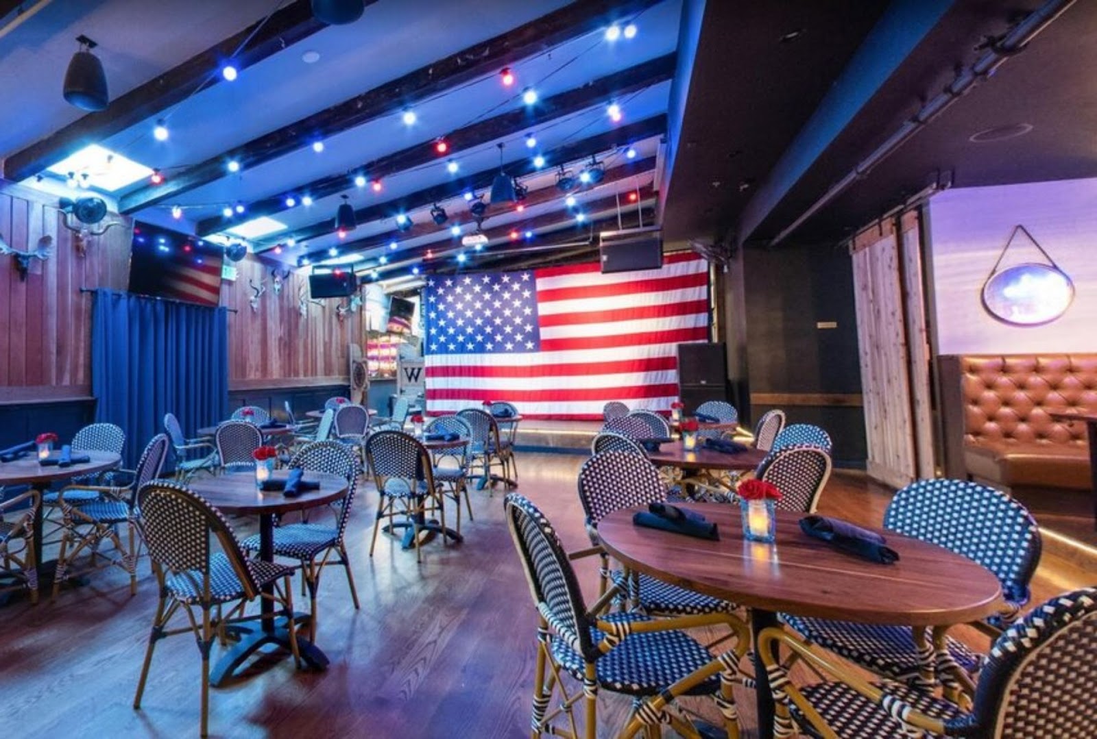 interior view of seating in Westwood restaurant, San Francisco, with the American Flag proudly hoisted on the stage