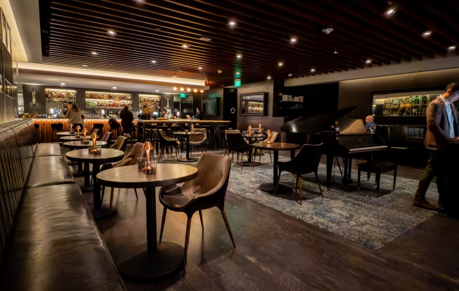 interior view of The Vault Steakhouse Piano Lounge, SF, with dining tables, bar, and pianist