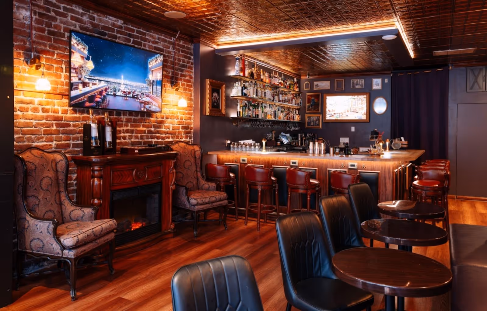 hearth, mounted television, and chairs surrounding a fully-stocked bar at RM 212, SF
