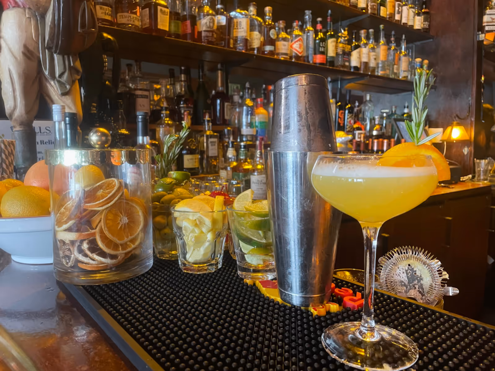 colorful cocktails on the counter of a fully-stocked bar
