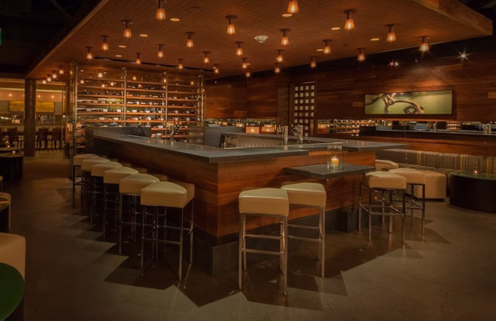 U-shaped bar, wine racks, and elegant lights in the interior of the Press Club restaurant, Union Square SF