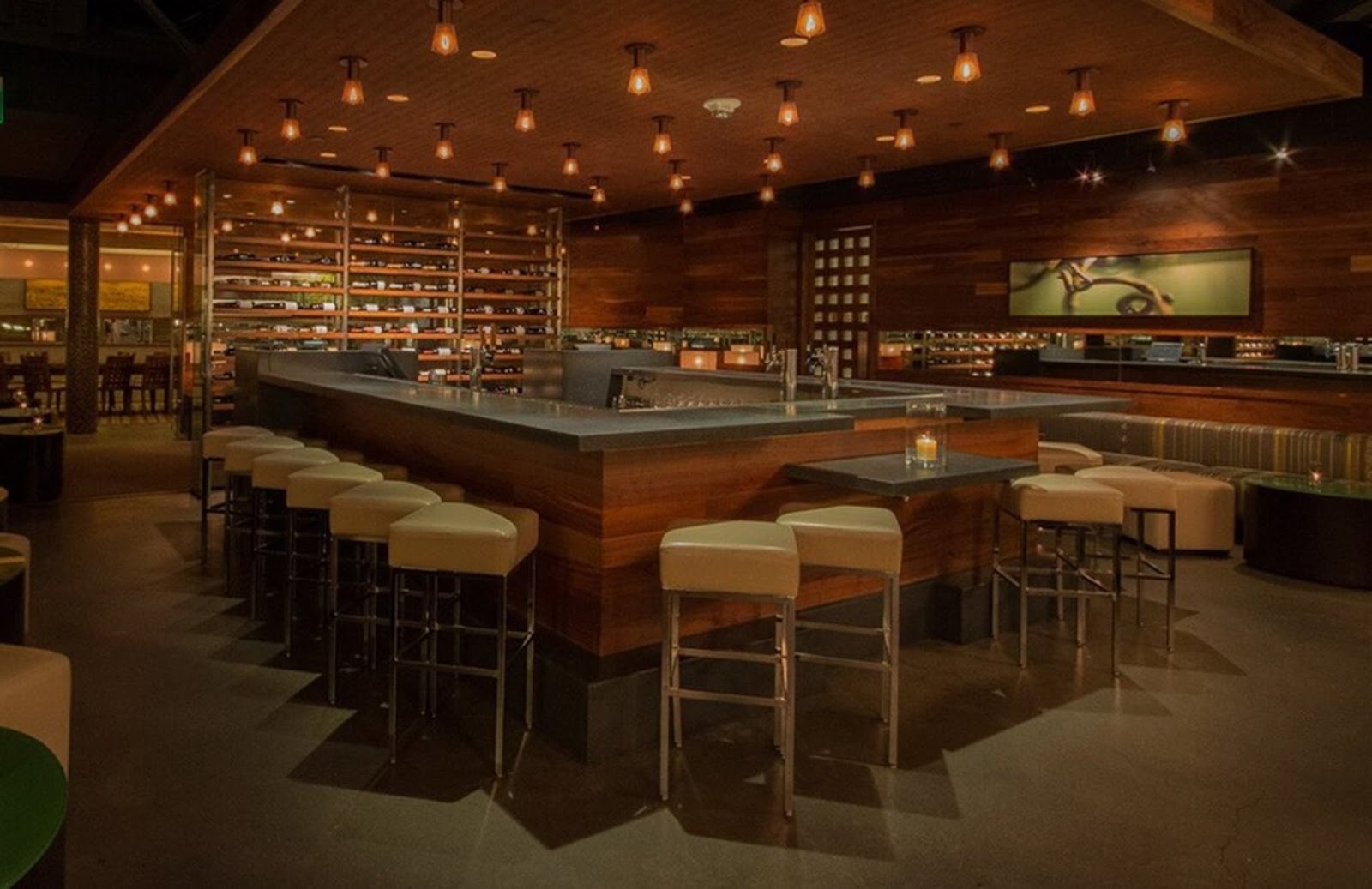 U-shaped bar, wine racks, and elegant lights in the interior of the Press Club restaurant, Union Square SF