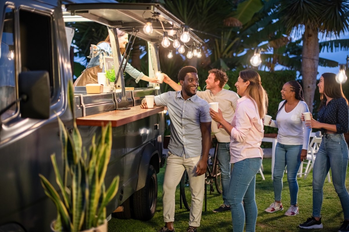 Food van at an outdoor event with string lights