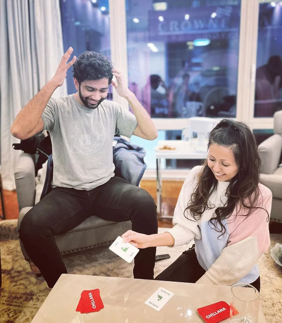 a man and a woman sitting at a table with cards