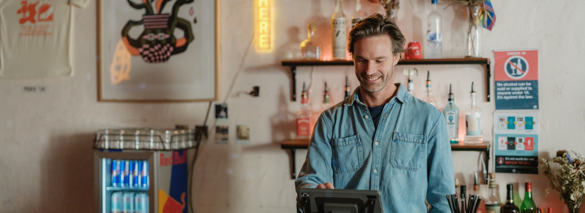 Bartender taking an order on a GoTab POS terminal behind the bar