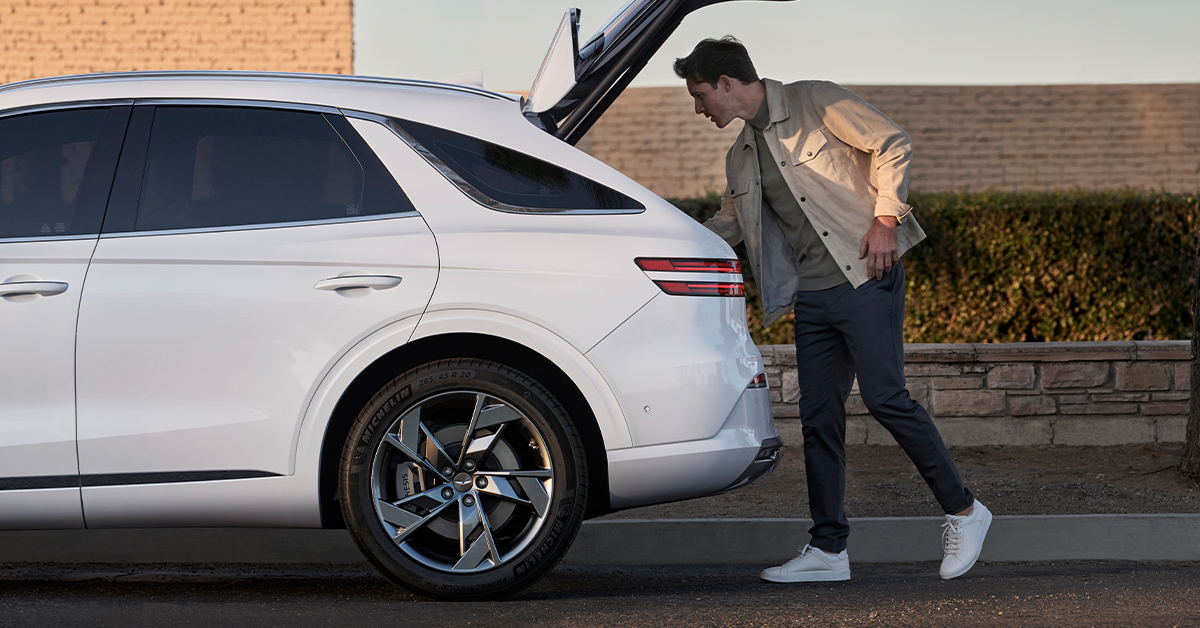 Side exterior view of the Genesis Electrified GV70 with open trunk
