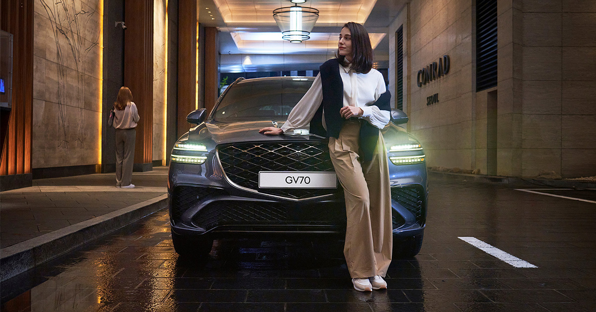Une femme appuyée contre un Genesis GV70