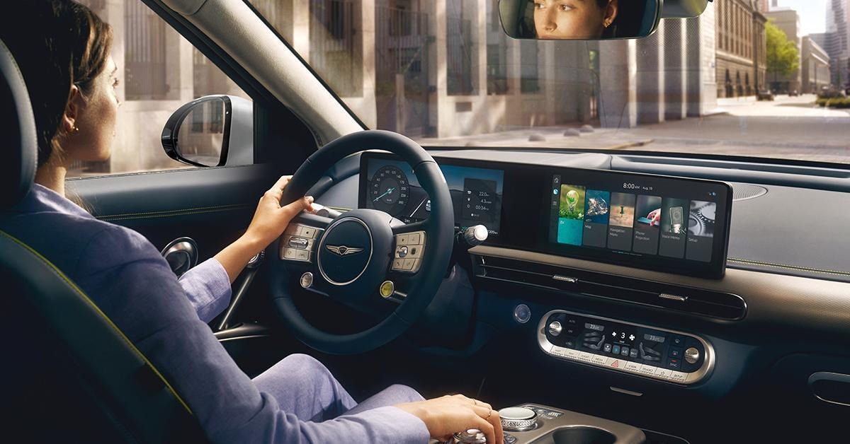 Interior view of Genesis GV60 with woman sitting in driver’s seat