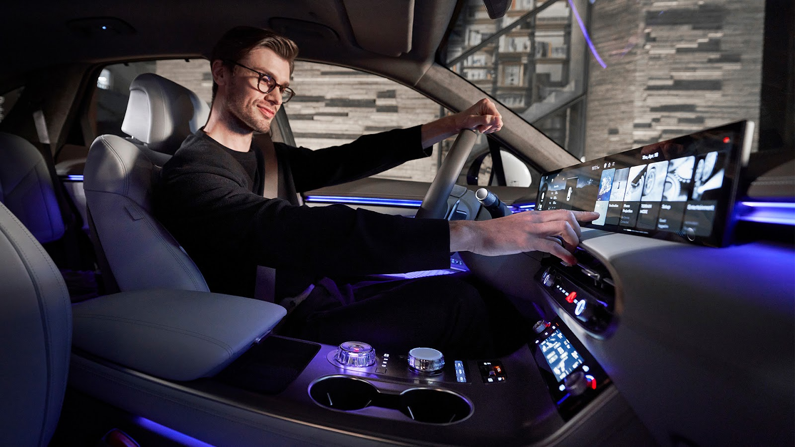 Un homme tend la main vers l'écran d'infodivertissement de la Genesis GV70