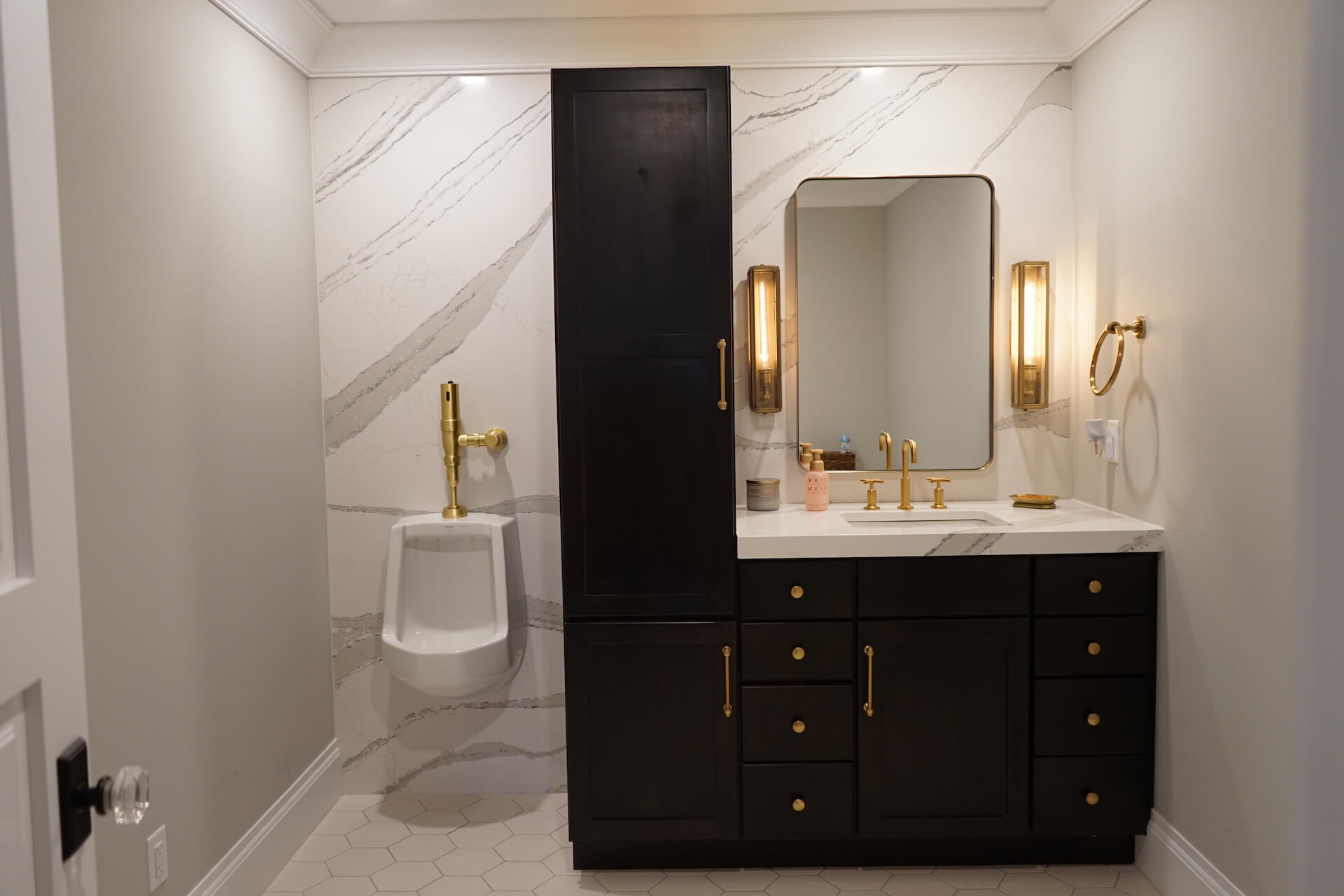 Modern bathroom with urinal and brass hardware