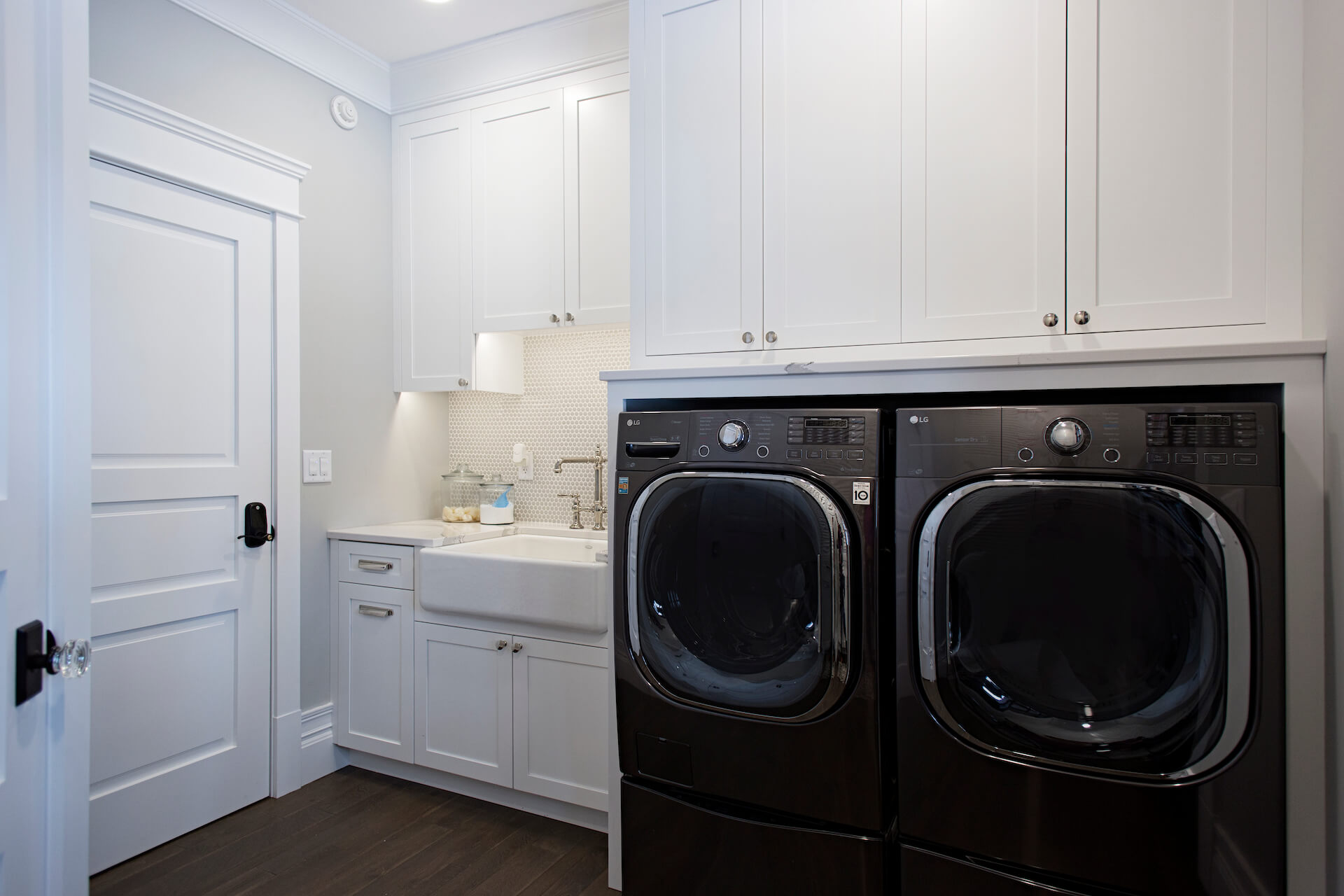 Modern white laundry room with penny tile backsplash
