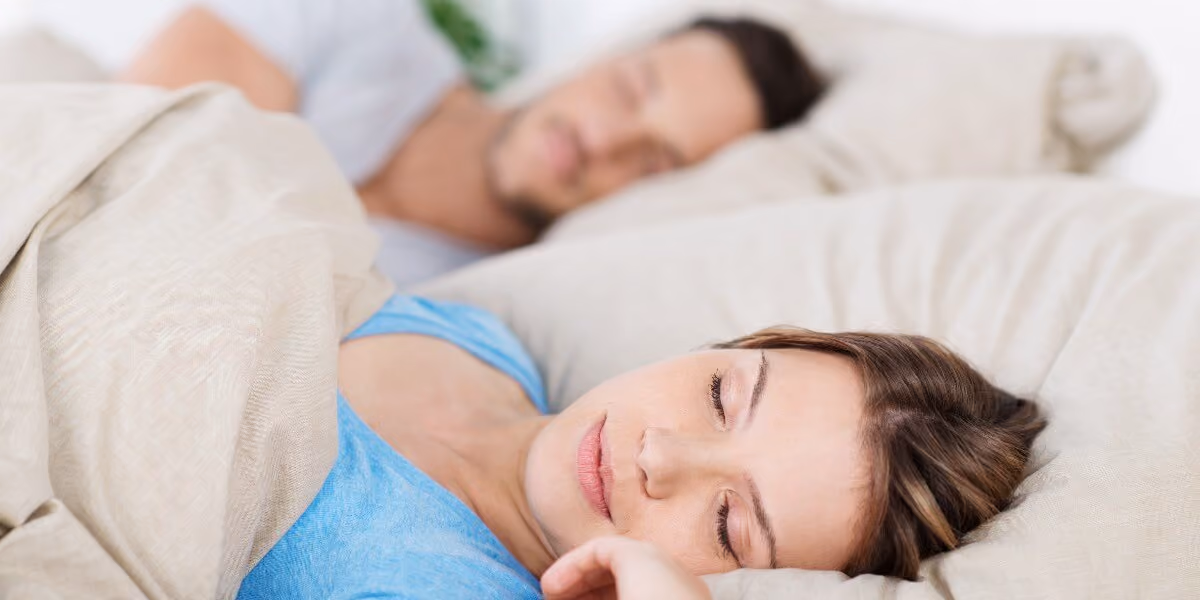 spouse tired of her husband snoring holding fingers in her ears