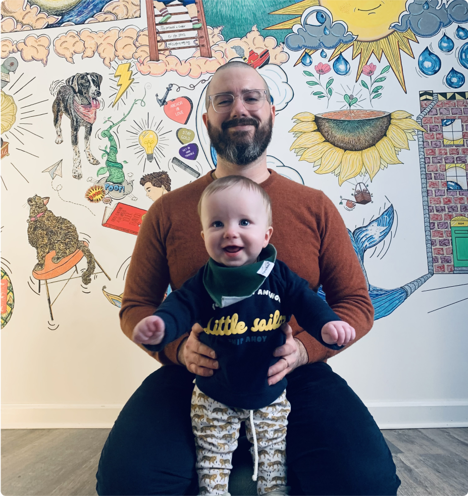 Image of website author and child smiling with wall mural in background