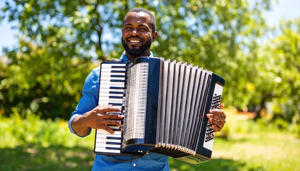 man playing the piano accordion outdoors