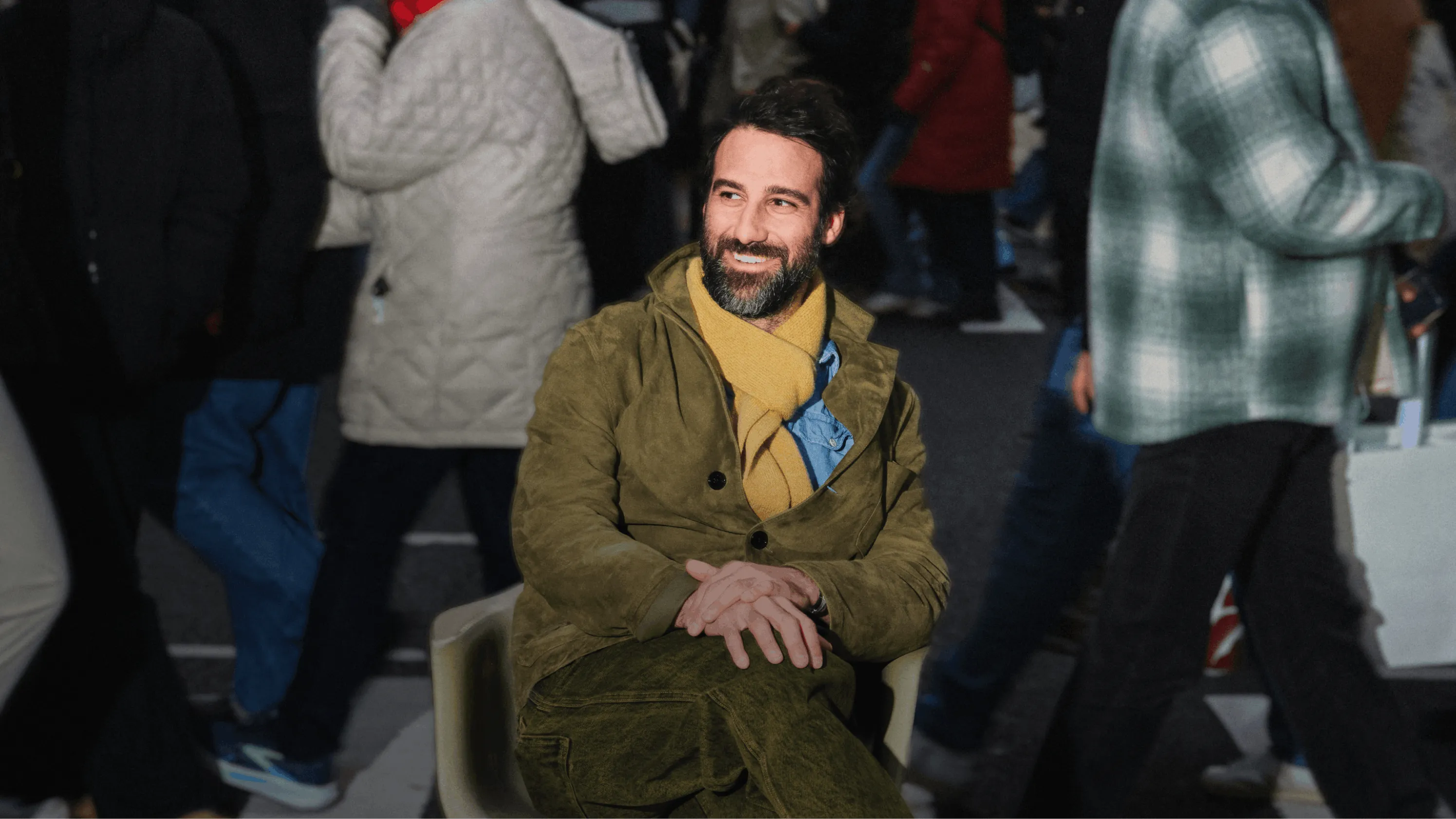 Mikey Ashmore, Sabah Owner, sitting in a chair cross legged in the middle of a busy crosswalk.