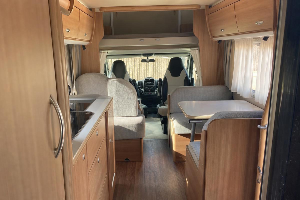 Interior de autocaravana perfilada mostrando salón y comedor