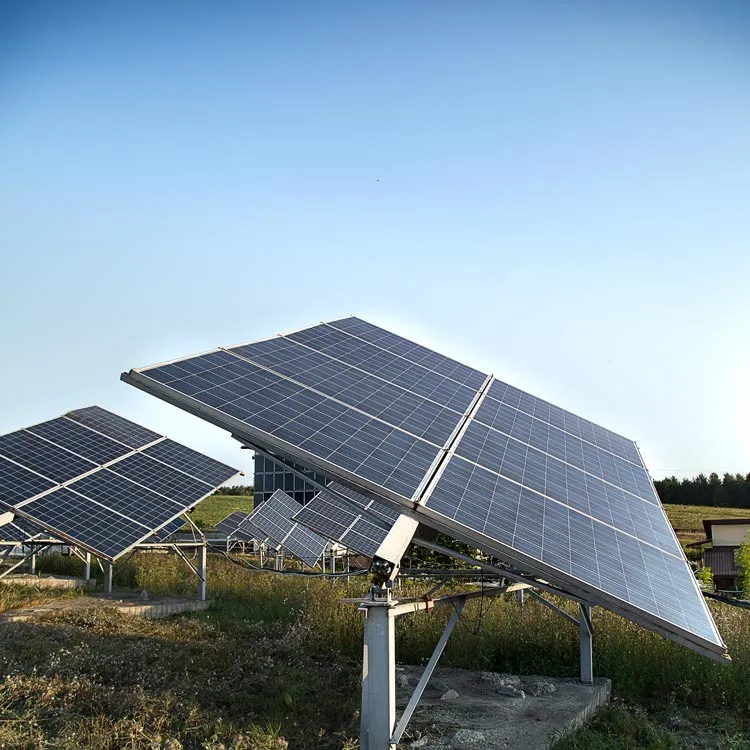 Large solar panels mounted on metal frames in a field under a clear blue sky, angled to capture sunlight efficiently.