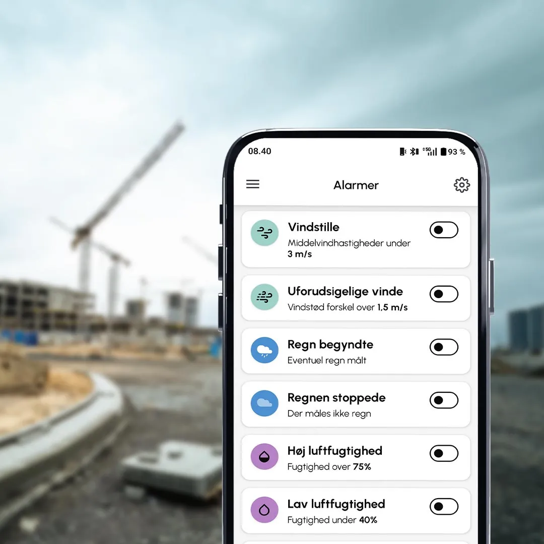 Smartphone with cordulus core app showing a wind alarm app with various wind condition notifications on a construction site.