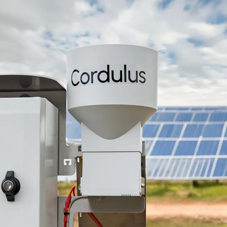 Close-up of a white Cordulus branded rain gauge device mounted outdoors with solar panels and partly cloudy sky in the background.